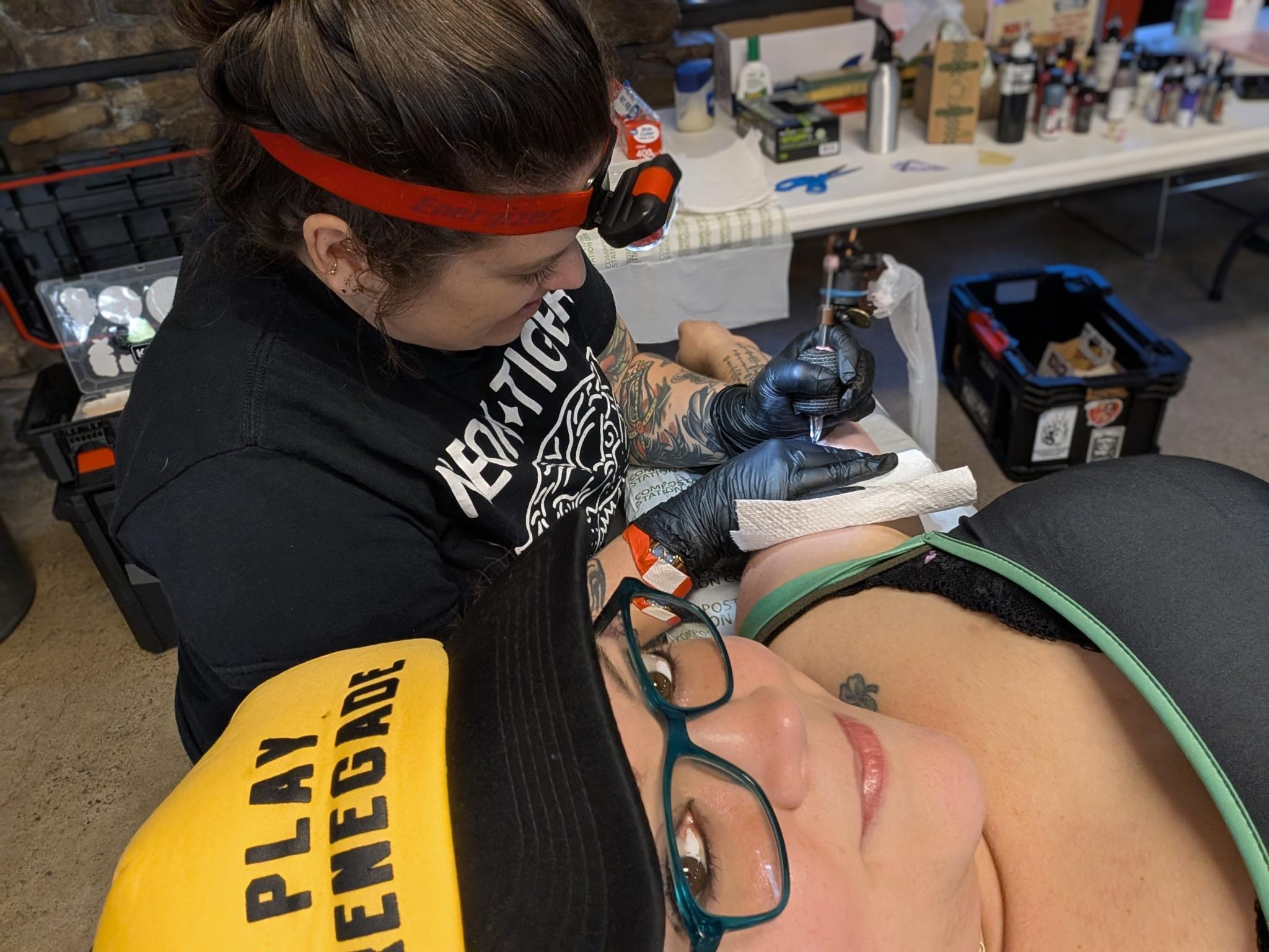 A photo of a guest at the Little Grassy Get Down getting a tattoo. 