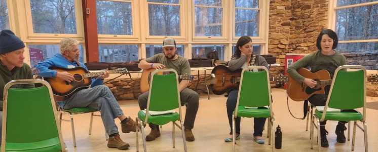 group of campers at the writing retreat playing guitars