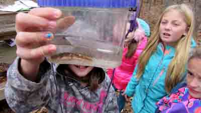 child holding up water in a container