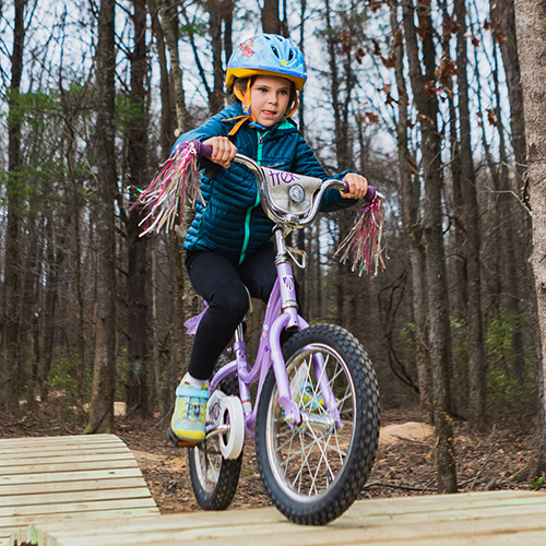 child riding on bike on terrain track